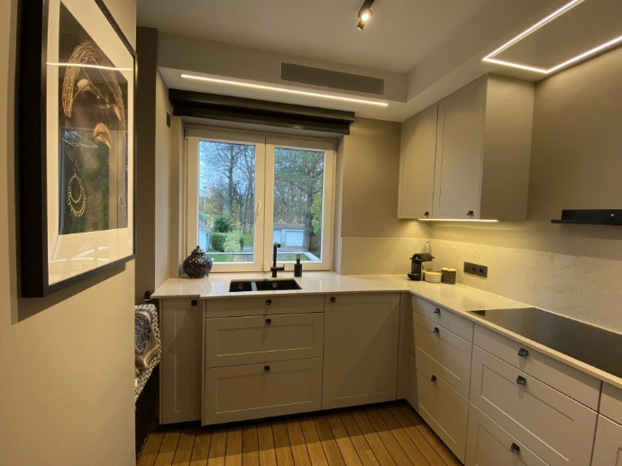 Cuisine en L sur mesure, façades laque mat et plan de travail en quartz, Arlon